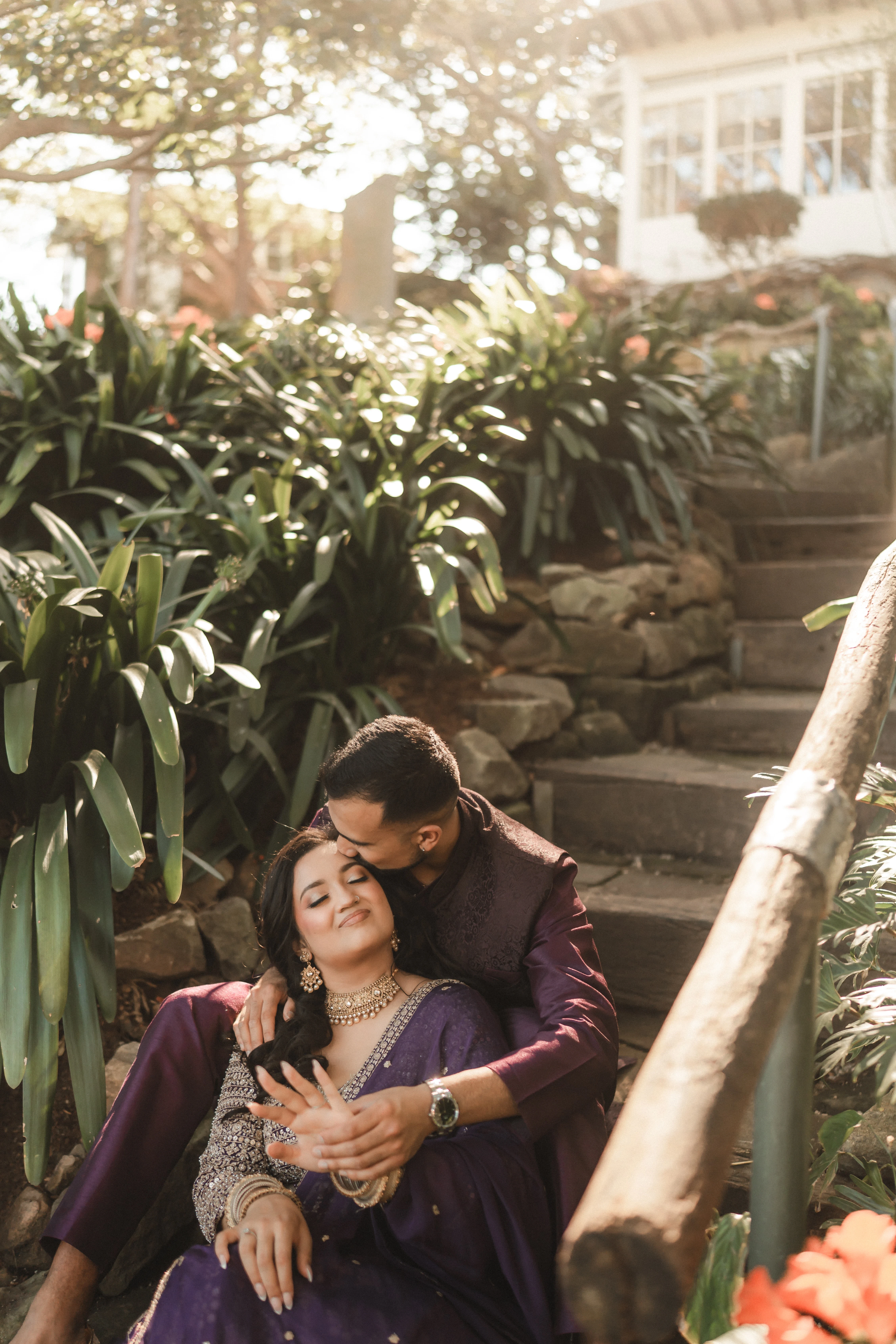 A South Asian couple seated on steps in a quiet embrace