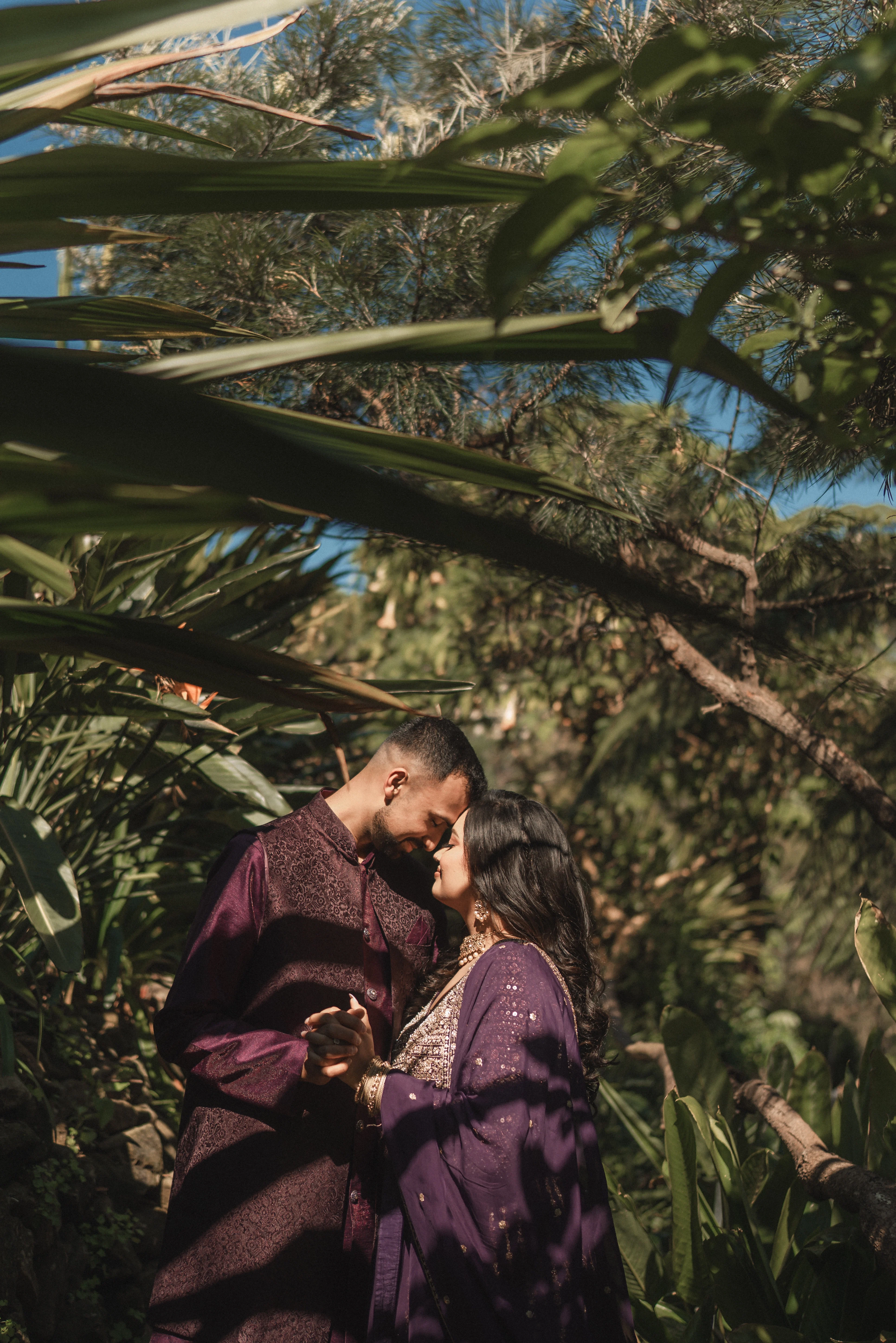 Couple in purple attire in a tropical garden